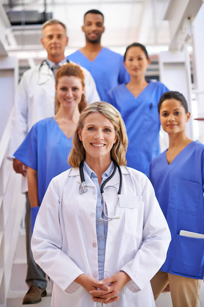 Були тут, щоб піклуватися про вас. Портрет різноманітної команди медичних працівників, що стоять на сходах у лікарні
. - Фото, зображення
