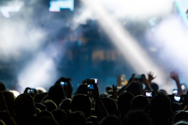 Люди фотографируют с помощью сенсорного смартфона во время музыки
  - Фото, изображение