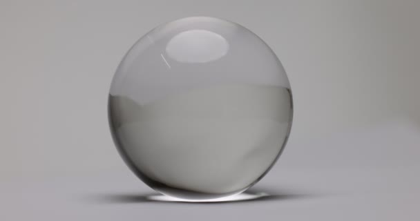 Clear glass transparent crystal lens ball rotating on white background  - Imágenes, Vídeo