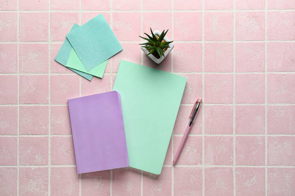 Notitieboekjes, plakkerige papieren, sappig en pen op roze achtergrond, bovenaanzicht - Foto, afbeelding