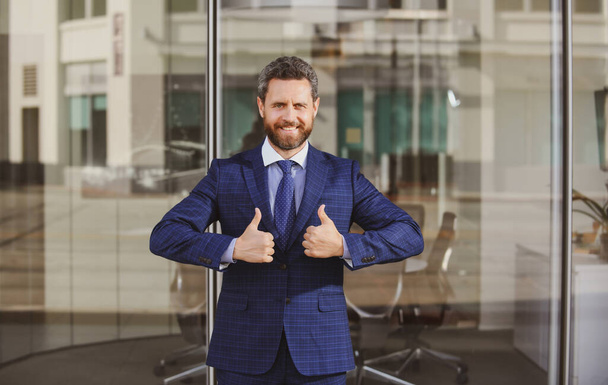 Businessman going thumbs up. Business man showing OK sign with his thumb up. - 写真・画像