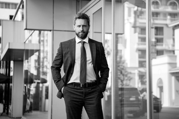 Portrait of a confident mature businessman standing outside office. - Фото, изображение