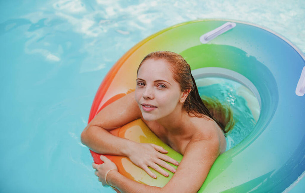 Letnia kobieta w stroju kąpielowym na nadmuchiwanym okręgu w basenie. - Zdjęcie, obraz
