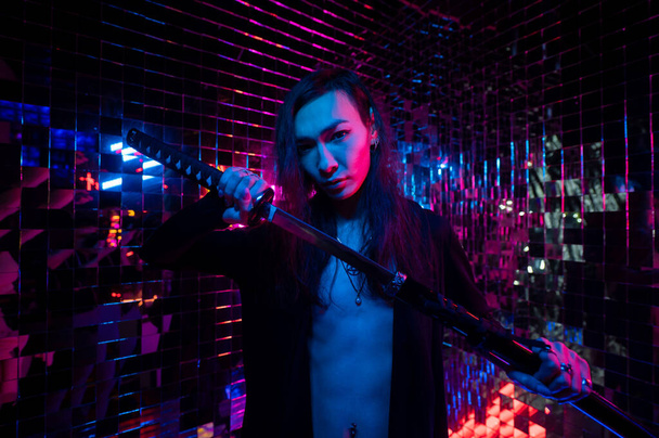 Male transgender neon light studio. Asian with samurai sword. - Foto, afbeelding