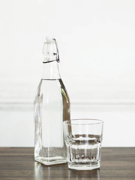 Flasche Wasser mit Glas auf dem Holztisch. - Foto, Bild