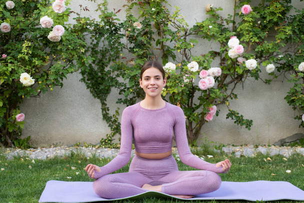 Meditation woman in summer blossom park. Young fit woman stretching. Sporty young girl doing fitness exercise, healthy life. Outdoor workout. - Foto, Bild