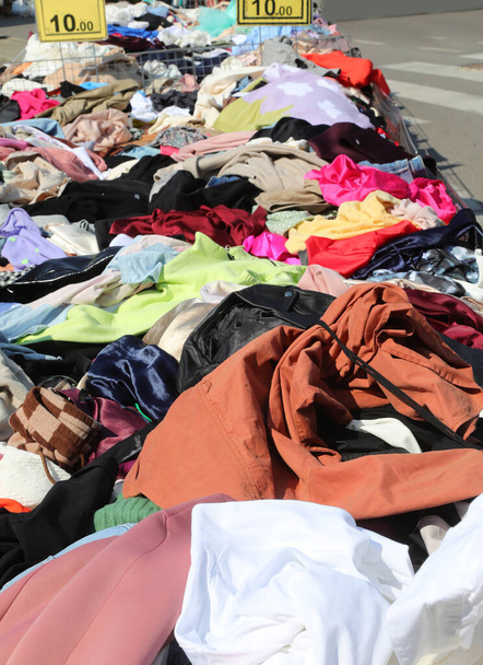 Stand mit bunten Kleidern, die tagsüber auf dem Wochenmarkt verkauft werden und der Preis auf dem Etikett - Foto, Bild