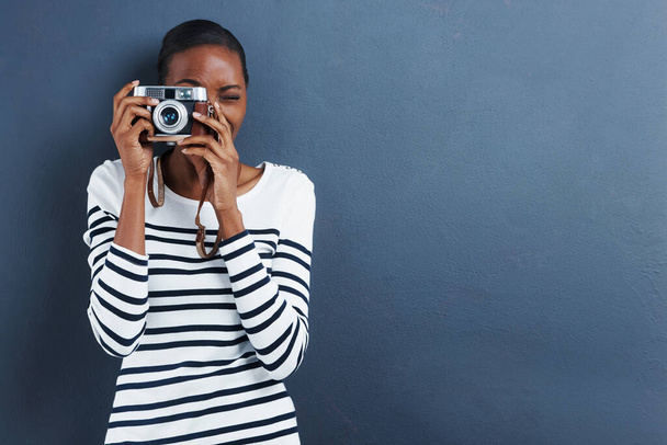 Lächeln. Aufnahme einer attraktiven jungen Frau, die ein Foto mit einer Vintage-Kamera macht. - Foto, Bild