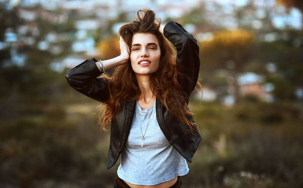 She knows just how to rock her natural beauty. Portrait of an attractive and stylish young woman spending some time outdoors. - Photo, Image