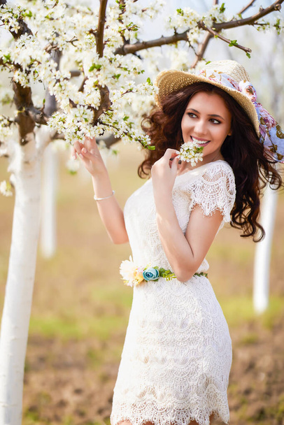 Portrét krásné ženy s dlouhými vlasy v blízkosti kvetoucích stromů na jaře. - Fotografie, Obrázek