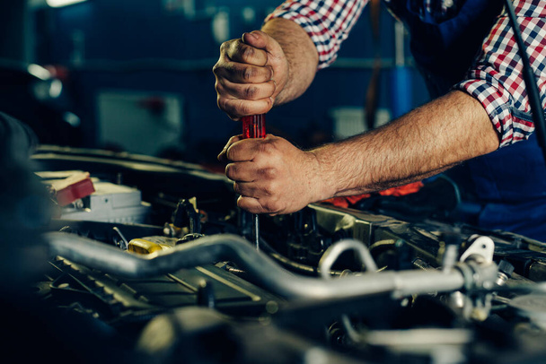 Automechanik pracující na automobilovém motoru v mechanické garáži. - Fotografie, Obrázek