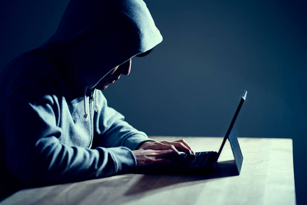 Male hacker writing code on a laptop - Фото, изображение