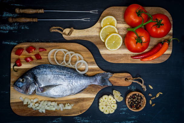 Rivi Lohen kalafilee, keittämätön eri mausteilla ja sitruunaviipaleella  - Valokuva, kuva