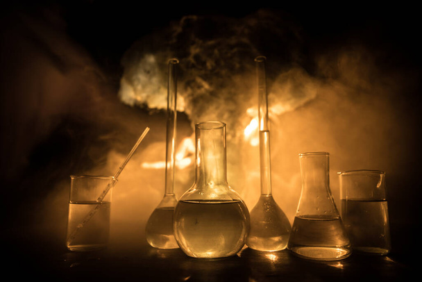 Pharmacy and chemistry theme. Test glass flask with solution in research laboratory. Science and medical background. Laboratory test tubes on abstract explosion cloud background. Selective focus - Foto, Imagen