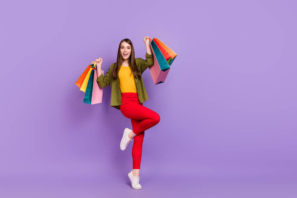 Full length body size view of attractive cheerful girl holding new things rejoicing isolated over violet purple color background - Valokuva, kuva