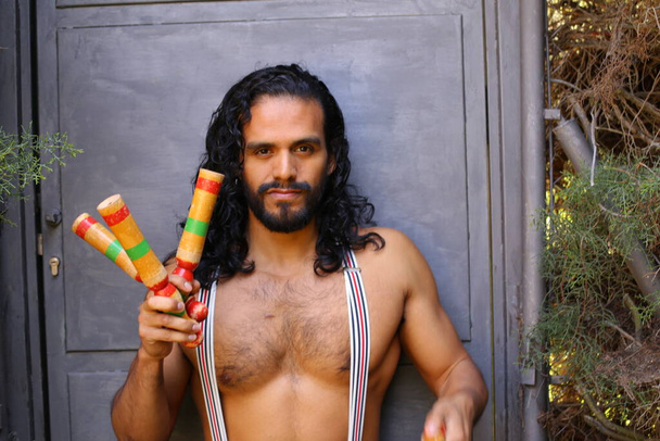 close-up portrait of handsome young man with colorful juggling sticks - Photo, Image