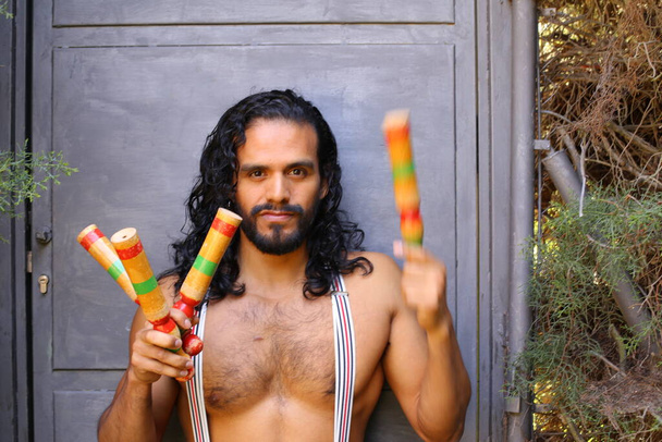 close-up portrait of handsome young man with colorful juggling sticks - Photo, Image