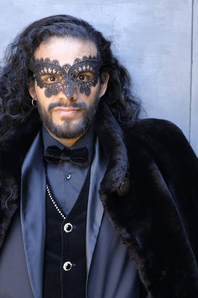 zblízka portrét pohledného mladého muže ve stylovém karnevalovém kostýmu a černé masce - Fotografie, Obrázek