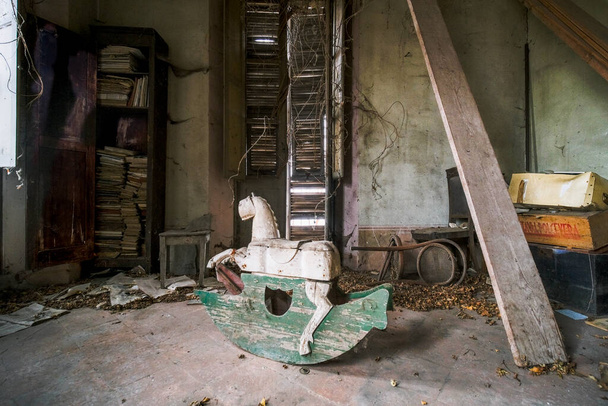 drewniany kucyk dla dzieci w starym opuszczonym domu. Wysokiej jakości zdjęcie - Zdjęcie, obraz