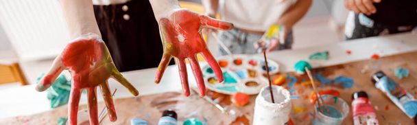 Kids are showing palms painted with watercolor - 写真・画像