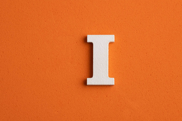 White wooden capital letter I on orange foamy background - Foto, Imagem