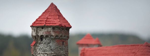 Modelo de juguete a escala histórica del castillo de Dinaburga. Murallas de ladrillo, torre de la fortaleza y aguja de primer plano. Parque natural Daugavas loki, Latgale, Letonia. Destinos turísticos, monumentos, visitas turísticas, historia, cultura - Foto, Imagen