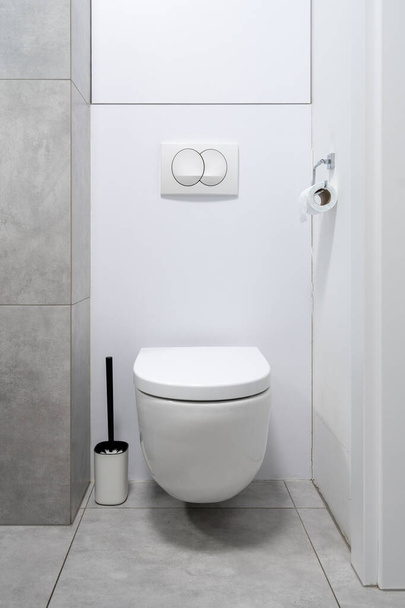Witte keramische toiletbril in eigentijdse badkamer interieur. Modern hotel sanitaire voorzieningen. Moderne voorzieningen voor mensen. Toiletartikelen - Foto, afbeelding