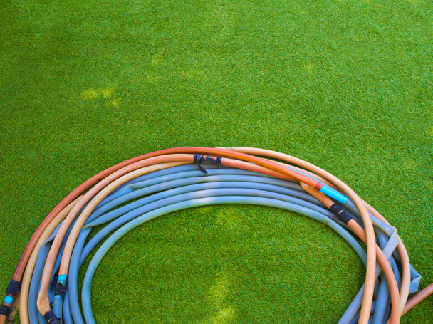Старий гумовий шланг на штучній траві
 - Фото, зображення