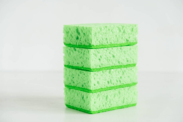 Green sponges for cleaning on a white background. - 写真・画像