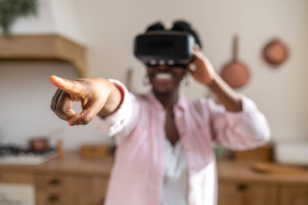 African woman in pink clothes in vr glasses looking excited - Photo, image