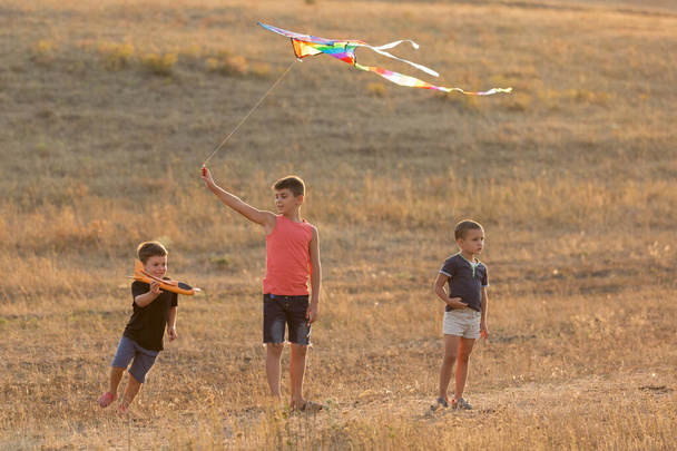 trois garçons jouent en plein air volant cerf-volant et avions, fun jeux d'été, style de vie - Photo, image