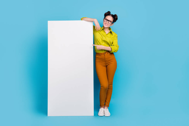 Full length photo of positive person indicate finger empty space blank isolated on blue color background - Fotoğraf, Görsel