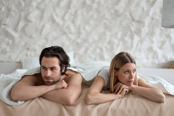Sexuelle Probleme, Beziehungskrise. Gestresstes junges Paar liegt im Bett, zu Hause mit familiären Schwierigkeiten überfordert - Foto, Bild