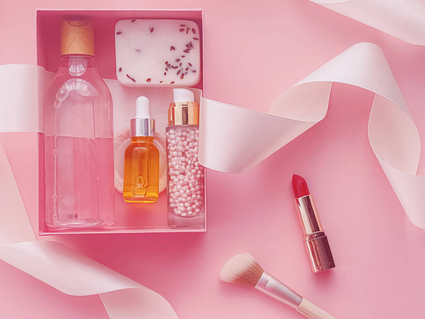 Πακέτο συνδρομής Beauty box με προϊόντα περιποίησης δέρματος, spa και καλλυντικών μακιγιάζ σε ροζ φόντο, σχεδιασμός flatlay, παράδοση φυσικών καλλυντικών δώρων - Φωτογραφία, εικόνα