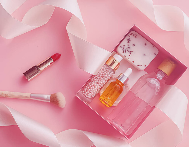 Πακέτο συνδρομής Beauty box με προϊόντα περιποίησης δέρματος, spa και καλλυντικών μακιγιάζ σε ροζ φόντο, σχεδιασμός flatlay, παράδοση φυσικών καλλυντικών δώρων - Φωτογραφία, εικόνα