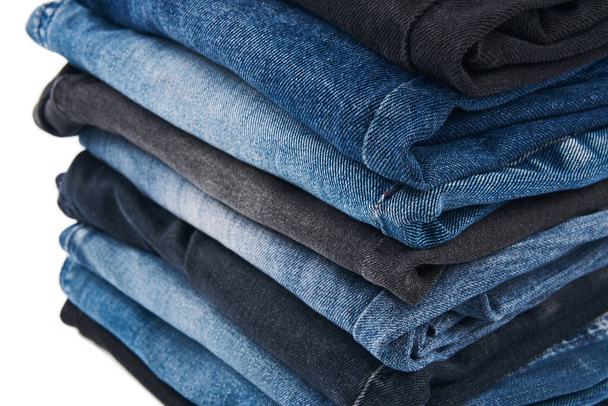 Empilement de diverses nuances de jeans bleus sur fond blanc texture jean denim. Texture de fond en denim pour le design. Texture toile denim. Denim bleu qui peut être utilisé comme fond. - Photo, image