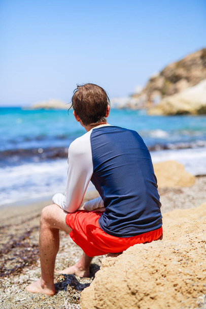 Back view of teenage boy at beach during summer vacation in Greece - Photo, Image