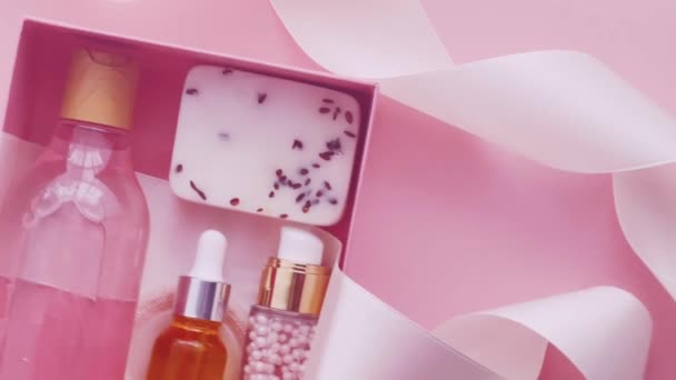 Pakiet subskrypcji Beauty Box z pielęgnacją skóry, spa i makijaż kosmetyki na różowym tle, projekt płaskowyżu, naturalne kosmetyki prezent koncepcji dostawy - Materiał filmowy, wideo