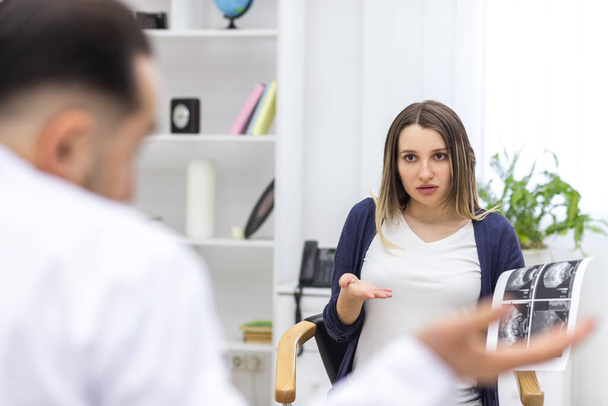 Photo of pregnant woman speaking with a doctor. - Foto, Imagem
