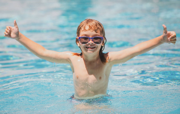 Child boy swim in swimming pool. Excited child in sunglasses in pool in summer day. - Zdjęcie, obraz