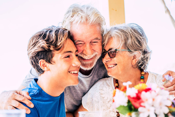 Boldog család a nagyszülőkkel és az unokával, együtt nevetnek és jól érzik magukat. Vidám idősek és fiatalok ölelkeznek a szerelemtől. Barátság vegyes generációkkal. Boldog emberek élvezik és mosolyognak - Fotó, kép