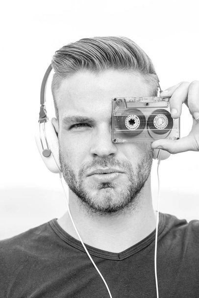 Man listening music with cassette and headphones. Emotional portrait guy. Retro player. Young bearded man in the style of the 90s. - 写真・画像