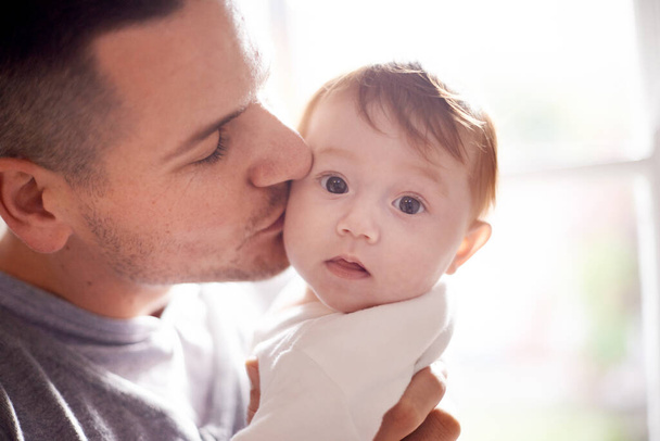 Daddys little girl. Shot of a young father kissing his baby daughter. - Foto, imagen