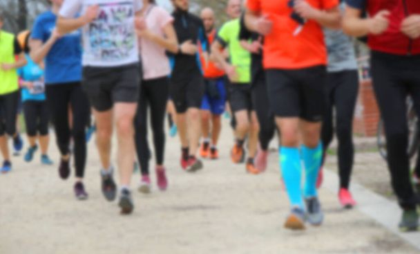 Opzettelijk wazig achtergrond met veel benen van lopers atleten tijdens cross-country hardlopen - Foto, afbeelding