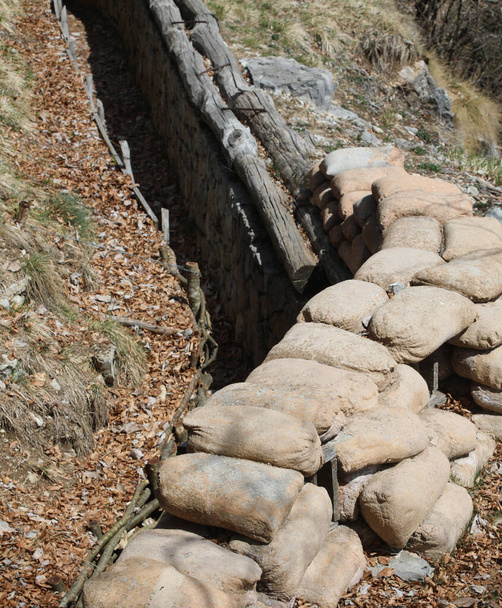 many sandbags to protect the trench dug in the ground by soldiers during the war - 写真・画像