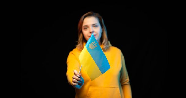 Ukrainan lippu. Kaunis ukrainalainen tyttö, jolla on hallituksen lippu kepillä mustalla pohjalla. Symboli Ukrainan valtion - Valokuva, kuva