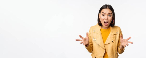 Asiático mulher zangada discutindo, apertando as mãos com raiva e gritando, gritando com rosto frustrado, de pé sobre fundo branco - Foto, Imagem