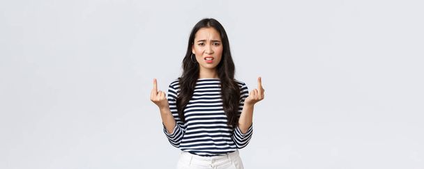 Lifestyle, beauty and fashion, people emotions concept. Annoyed pissed-off asian woman stare bothered and displeased, showing middle-fingers careless what people say, white background - Fotografie, Obrázek