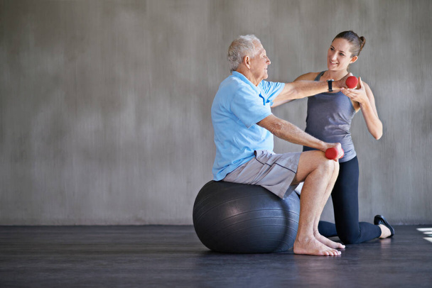 Допомагати пацієнтам залишатися сильними та здоровими. Знімок фізичного терапевта, що працює з літнім чоловіком
. - Фото, зображення