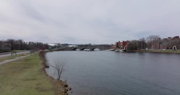 Winter or early spring landscape in city. Forwards fly above Charles river at Weld Boat House. Vehicles driving on Anderson Memorial Bridge. Boston, USA - Footage, Video